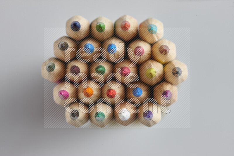 تظهر الصورة لقطة علوية لأقلام تلوين خشبية علي خلفية رمادية