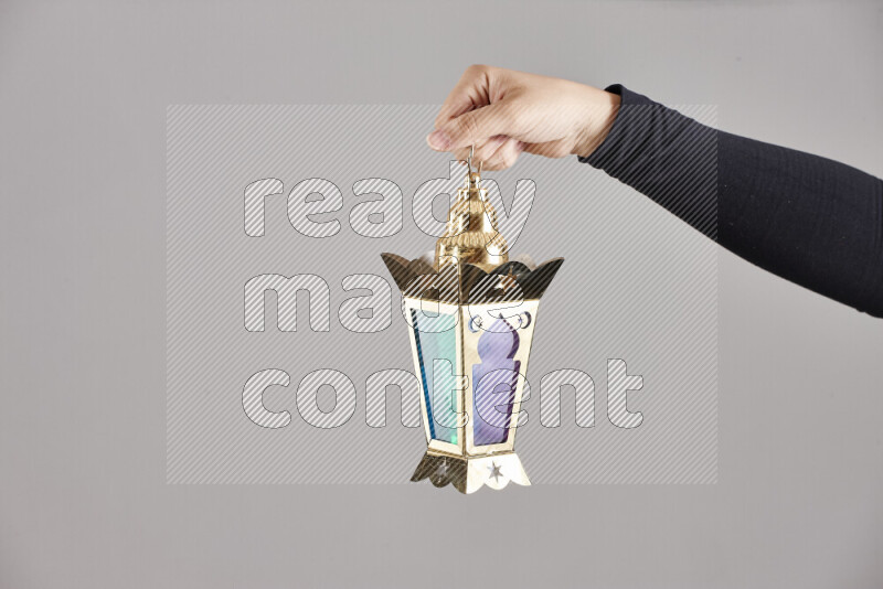 A woman in black abaya holding different ramadan lanterns in different positions
