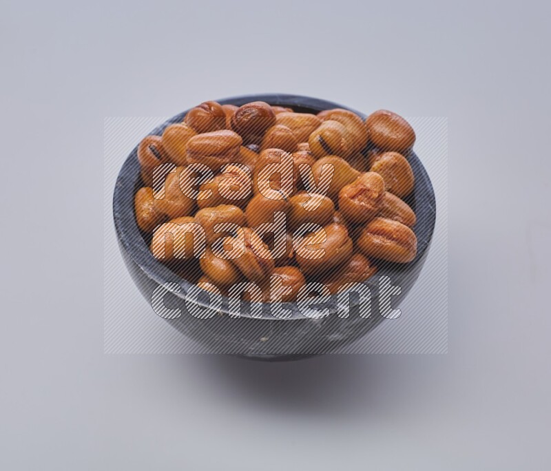 Close up shot of cooked fava beans (foul) in a container on white background