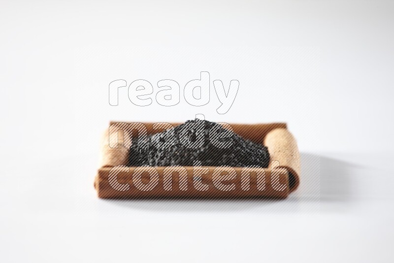 A single square of cinnamon sticks full of black seeds on white flooring