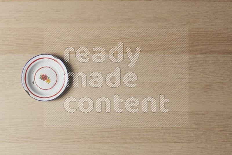 A vintage metal plate on light wooden background