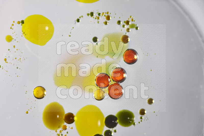 Close-ups of abstract red, green and yellow watercolor drops on oil Surface on white background