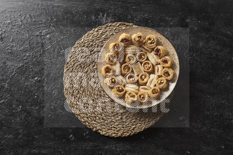 حلويات شرقية في أطباق فخارية علي خلفية سوداء خشبية