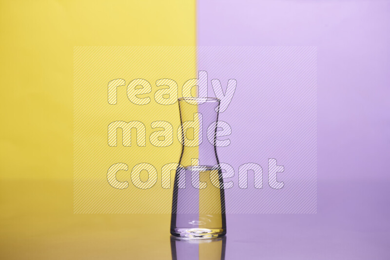 The image features a clear glassware filled with water, set against yellow and light purple background