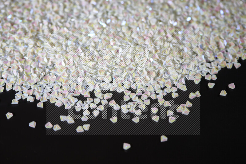 Colorful plastic shards for decoration scattered on a black background