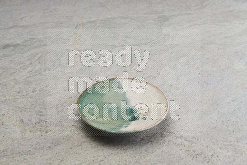 A multicolored pottery plate on grey marble background