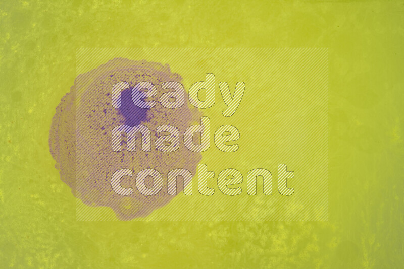 The image captures a dramatic splatter of purple paint over a yellow backdrop