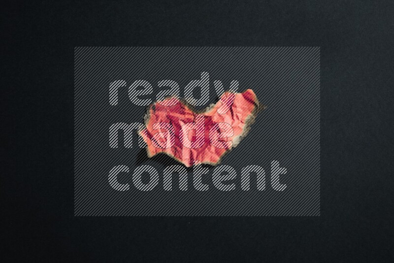 Burnt multicolored paper on black background