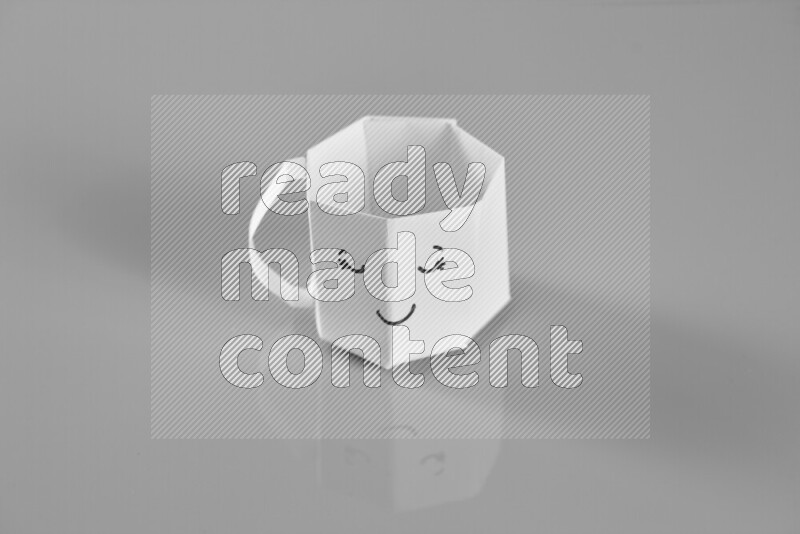 Origami cup on grey background
