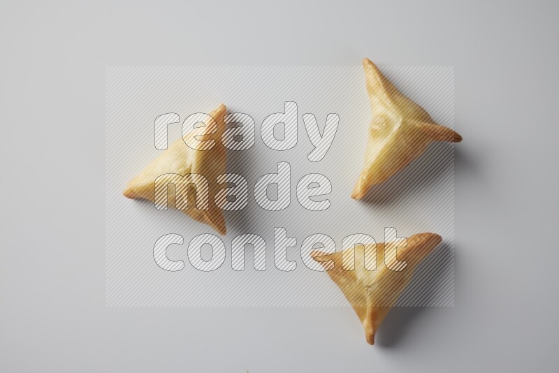 Three fried sambosa from a top angle on a white background