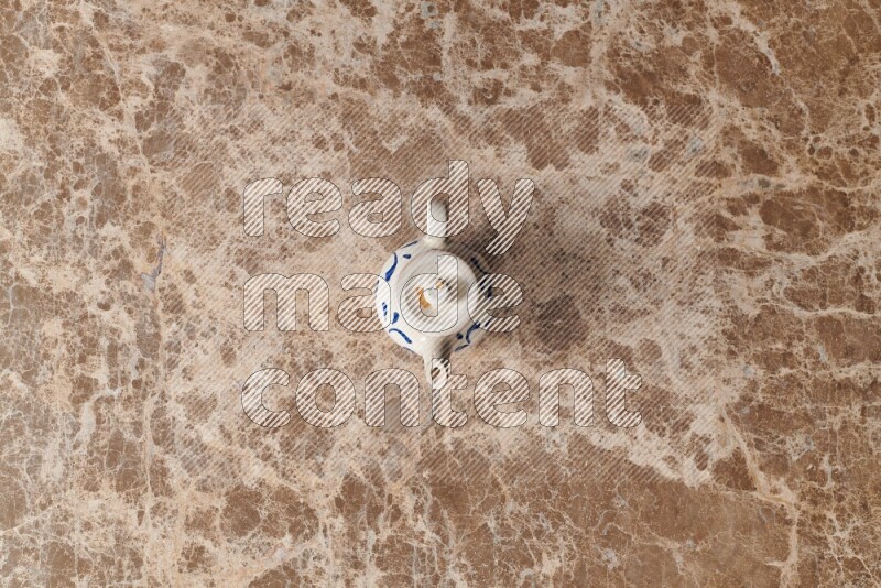 إبريق شاي فخاري على خلفية رخام بيج