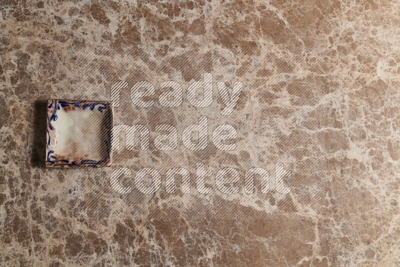 A decorative pottery plate on beige marble background