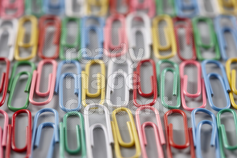 Multicolored paper clips isolated on a grey background