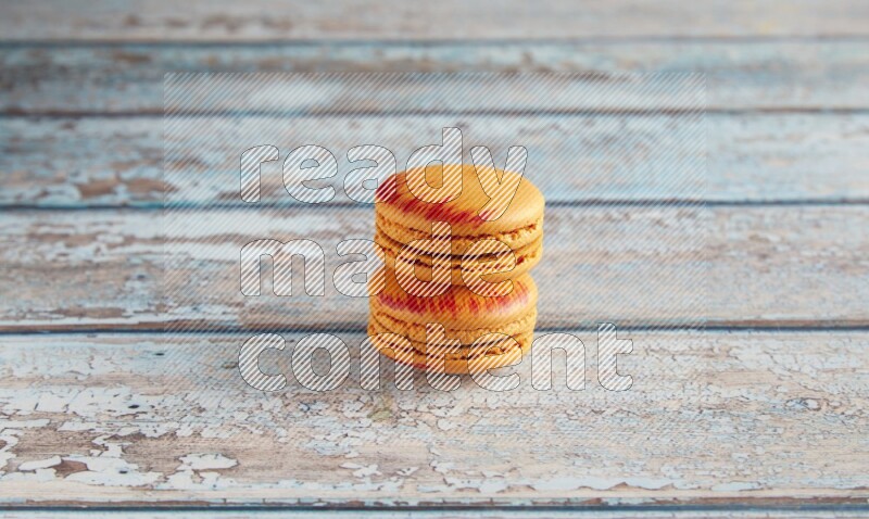 45º Shot of two orange Exotic macarons on light blue wooden background