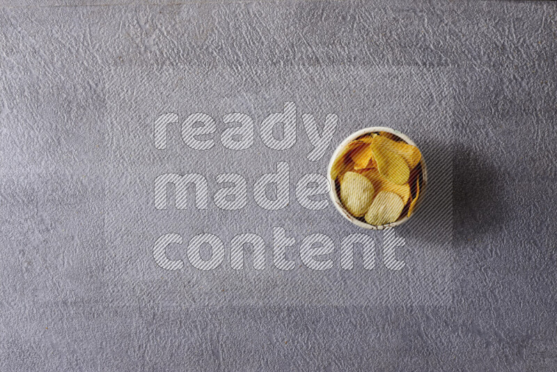 Assorted snacks in pottery bowls on grey background