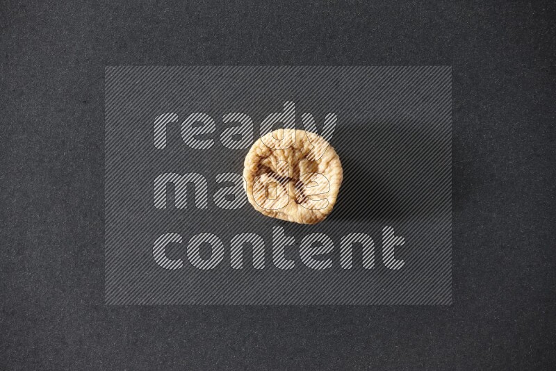 حبة واحدة من التين المجفف على خلفية سوداء