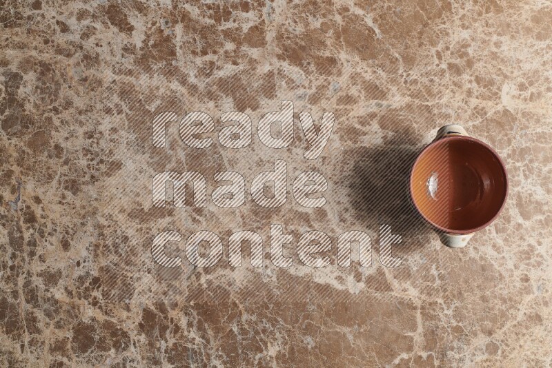 A multicolored pottery pot on beige marble background