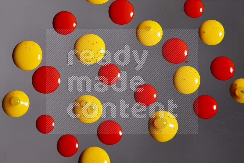 Close-ups of abstract red and yellow paint droplets on the surface