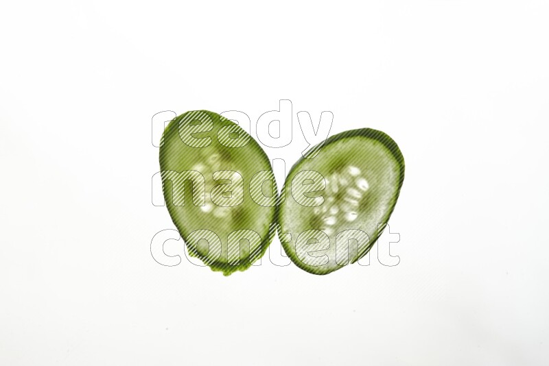 Cucumber slices on illuminated white background