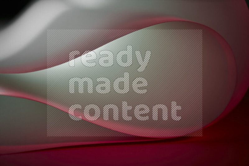 An abstract art piece displaying smooth curves in red and white gradients created by colored light