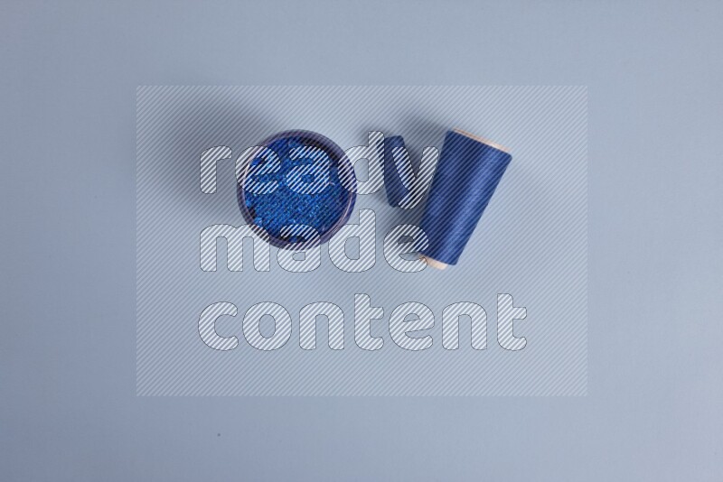 A blue collection of sewing and tailoring tools arranged on a blue background