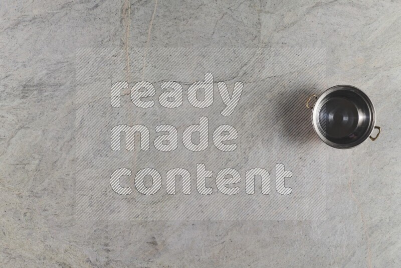 A small copper pot on grey marble background