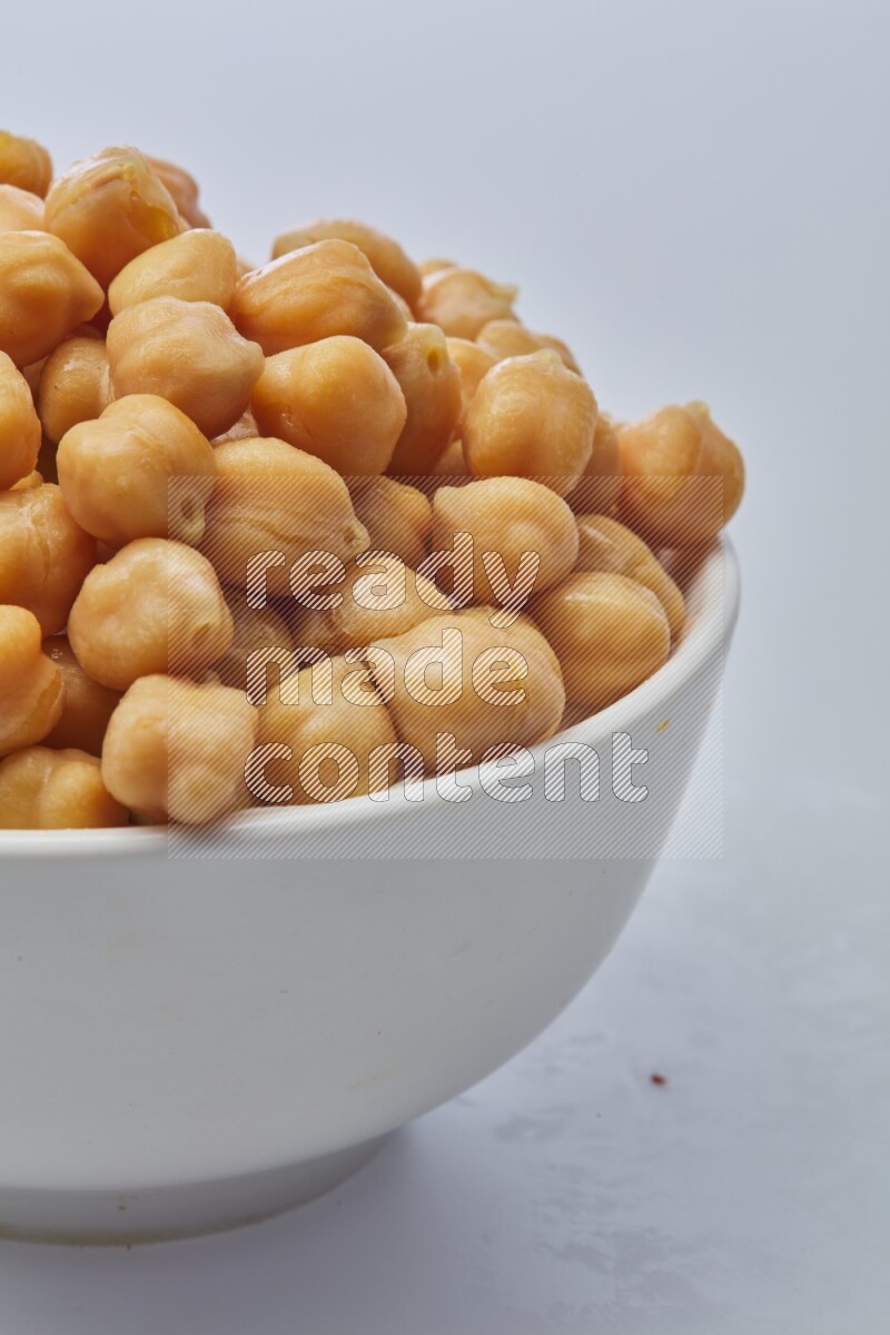 Close up of a boiled chickpeas in a container on white background