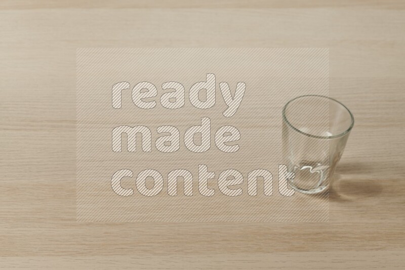 An empty glass cup on light wooden background