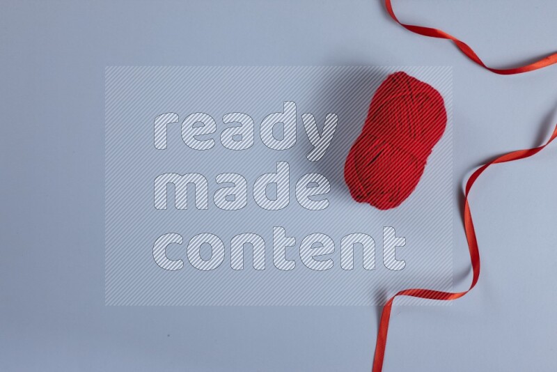 A red collection of sewing and tailoring tools arranged on a blue background