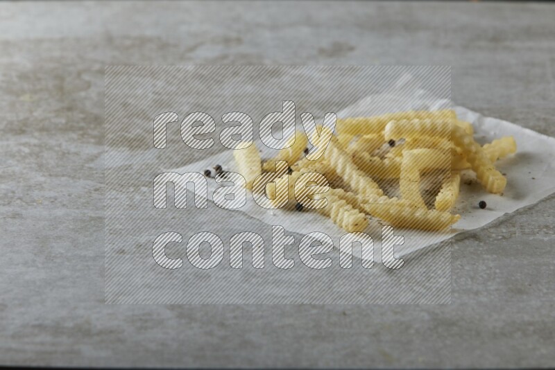 crinkle fries on parchment paper on grey textured counter top