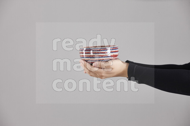 A woman in black abaya holding different pottery essentials in different positions