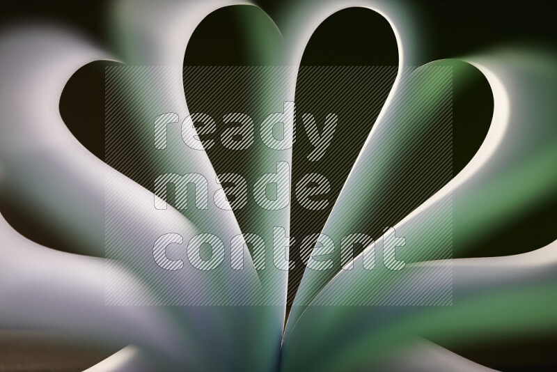 An abstract art piece displaying smooth curves in white and green gradients created by colored light