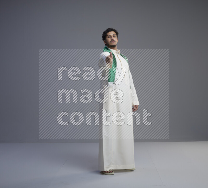 رجل سعودي يرتدي ثوب ابيض و شال يتفاعل مع الكاميرا