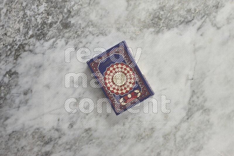Quran with a prayer beads on grey marble background