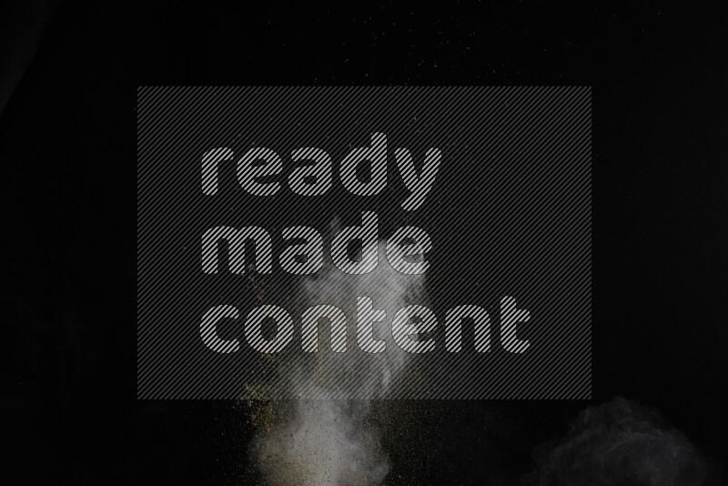A side view of brown powder explosion on black background