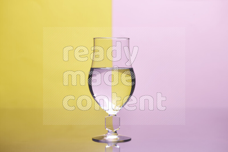 The image features a clear glassware filled with water, set against yellow and rose background
