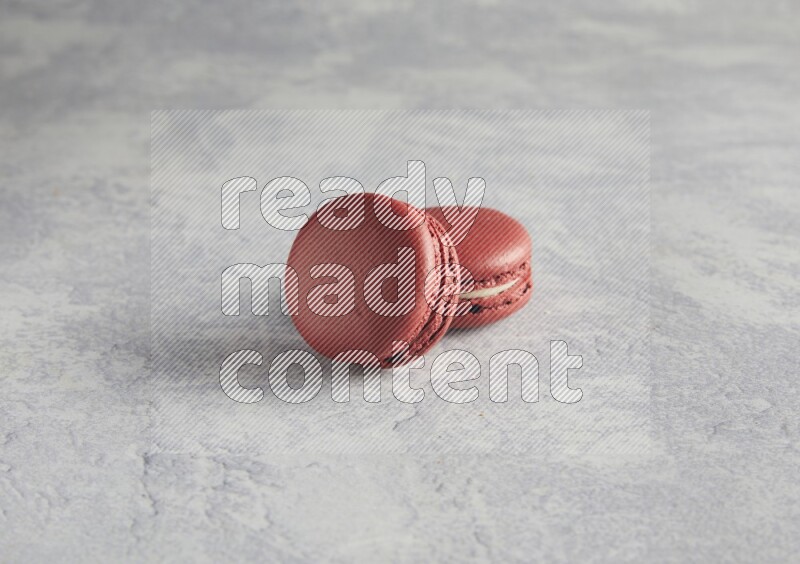45º Shot of two Red Velvet macarons  on white  marble background