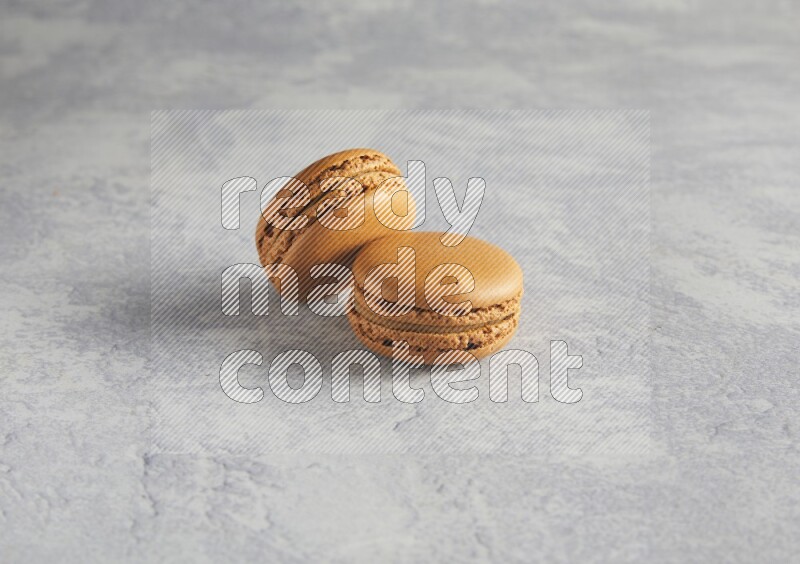 45º Shot of two Brown Maple Taffy macarons  on white  marble background