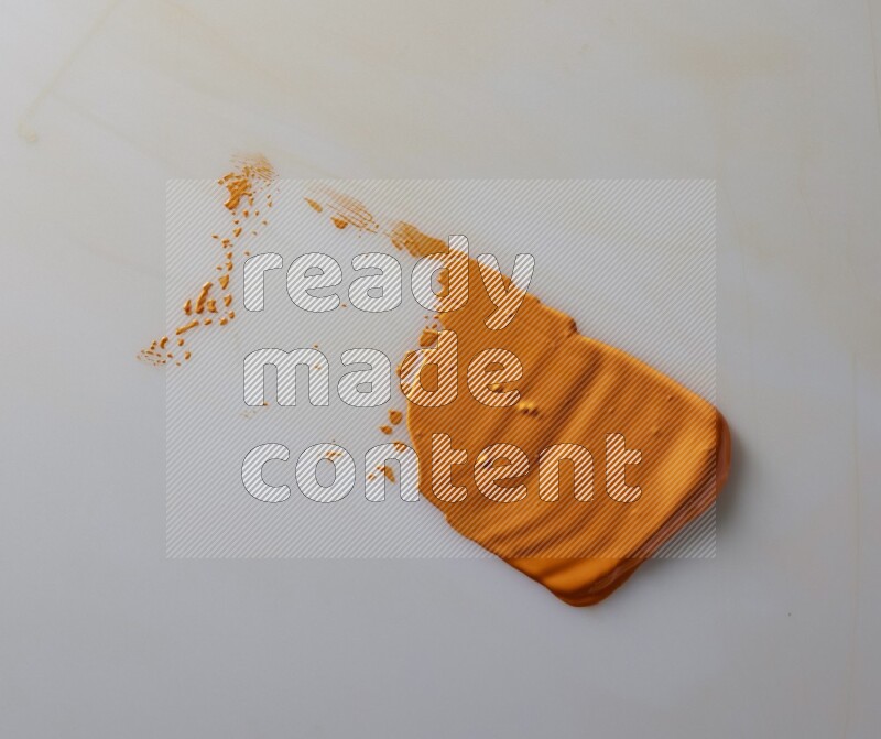 An orange straight painting knife stroke on white background