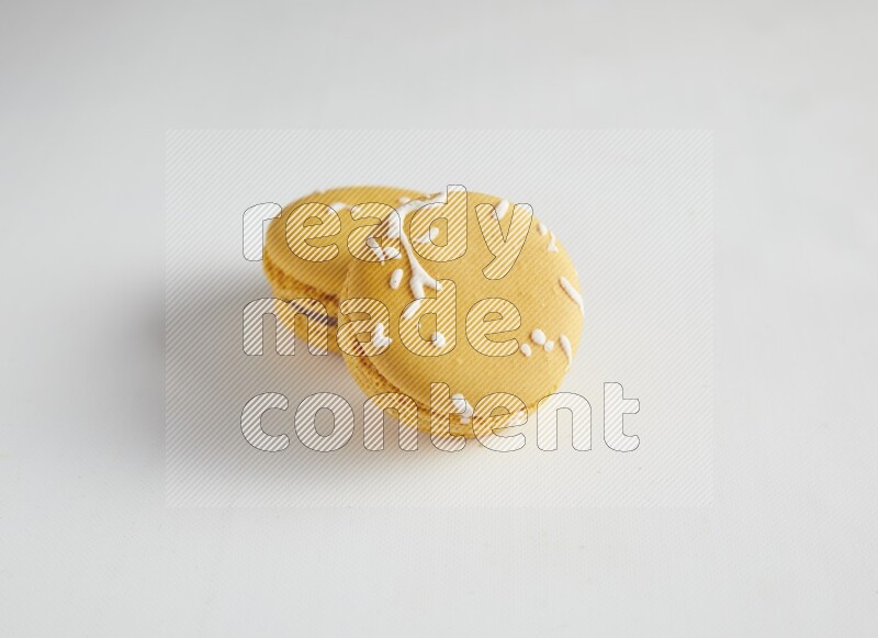 45º Shot of two Yellow Piña Colada macarons on white background