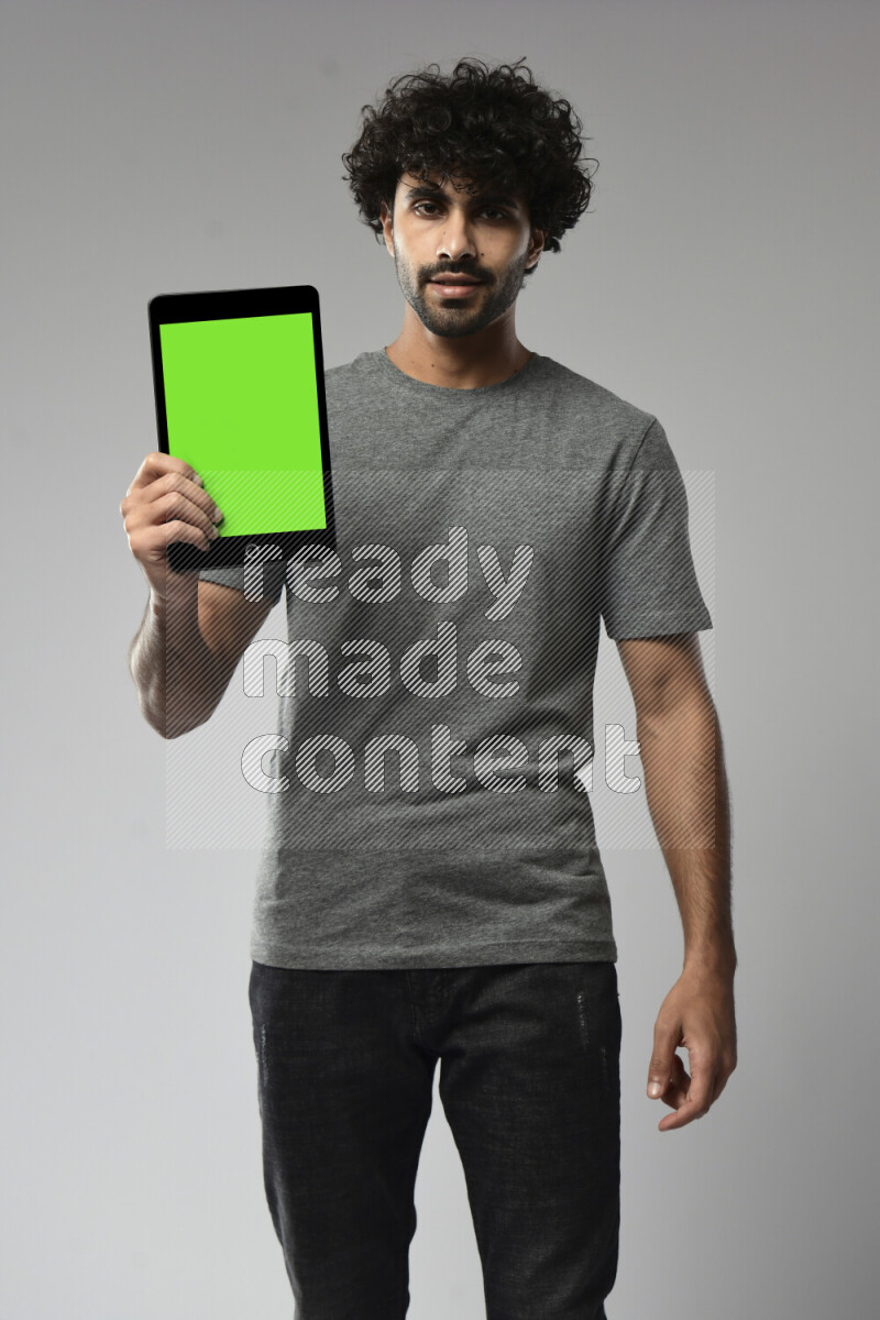 A man wearing casual standing and showing a tablet screen on white background