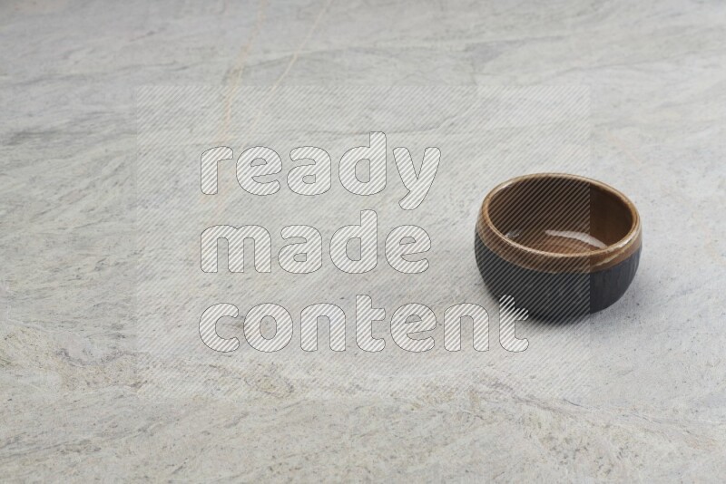 A multicolored pottery bowl on grey marble background