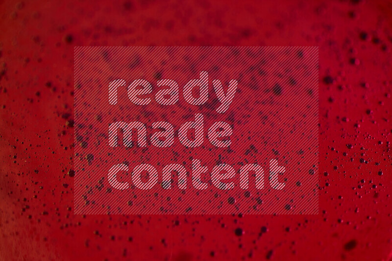 Close-ups of abstract blue watercolor drops on oil Surface on red background