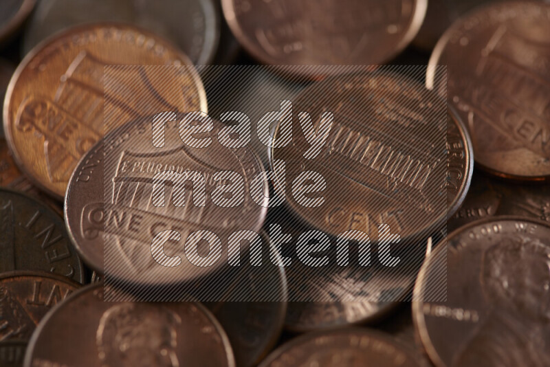 A close-up of scattered United States one cent coins on grey background