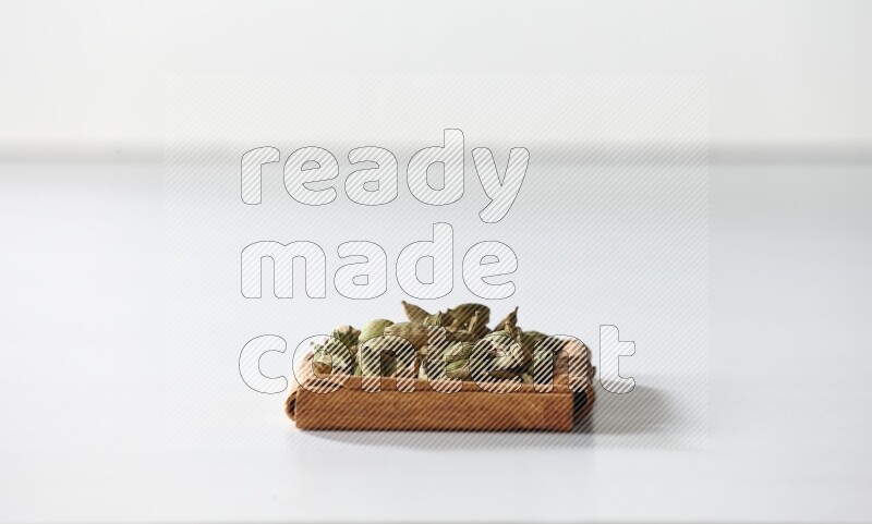A single square of cinnamon sticks full of cardamom on white flooring