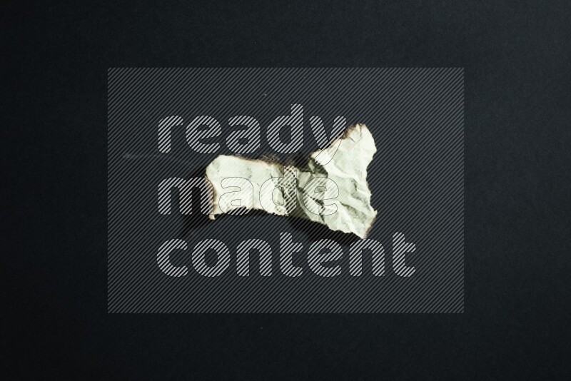 Burnt multicolored paper on black background