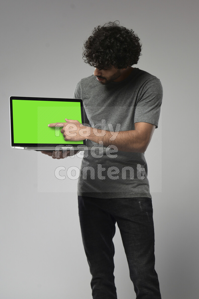 A man wearing casual standing and showing a laptop screen on white background