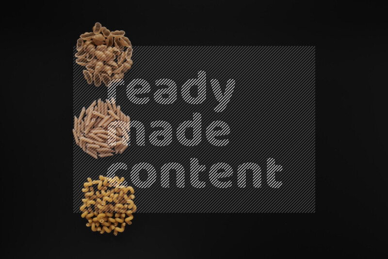 Different pasta types in 3 bunches on black background