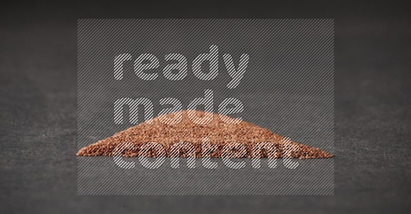 Garden cress seeds in a triangle shape on a black flooring