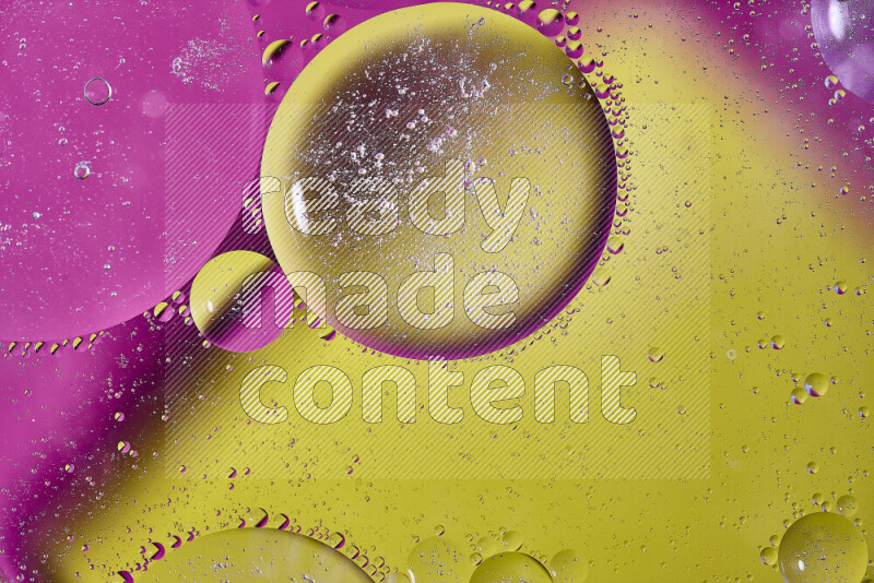 لقطات مقربة لفقاعات من الزيت على سطح الماء باللون الأصفر والوردي